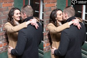 Woman in brown dressy coat with white turtle neck and man in black coat leaning against a wall, about to kiss. Two side by side photos. In the one on the right, he is sticking her tongue out at her and she is smiling at him. In the photo on the right, they are kissing.